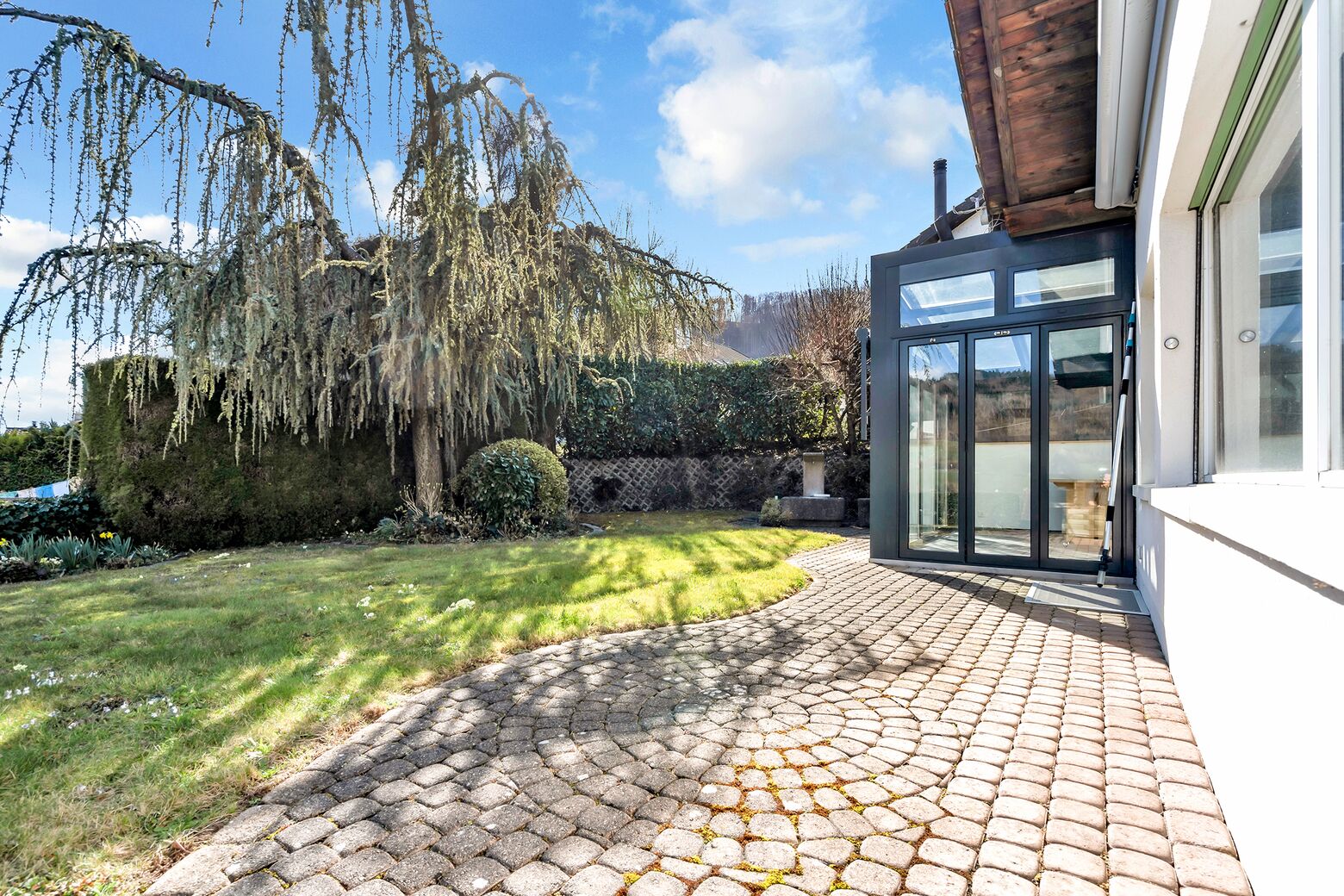 Aussenansicht Südfassade mit Sitzplatz und Blick zum Wintergarten