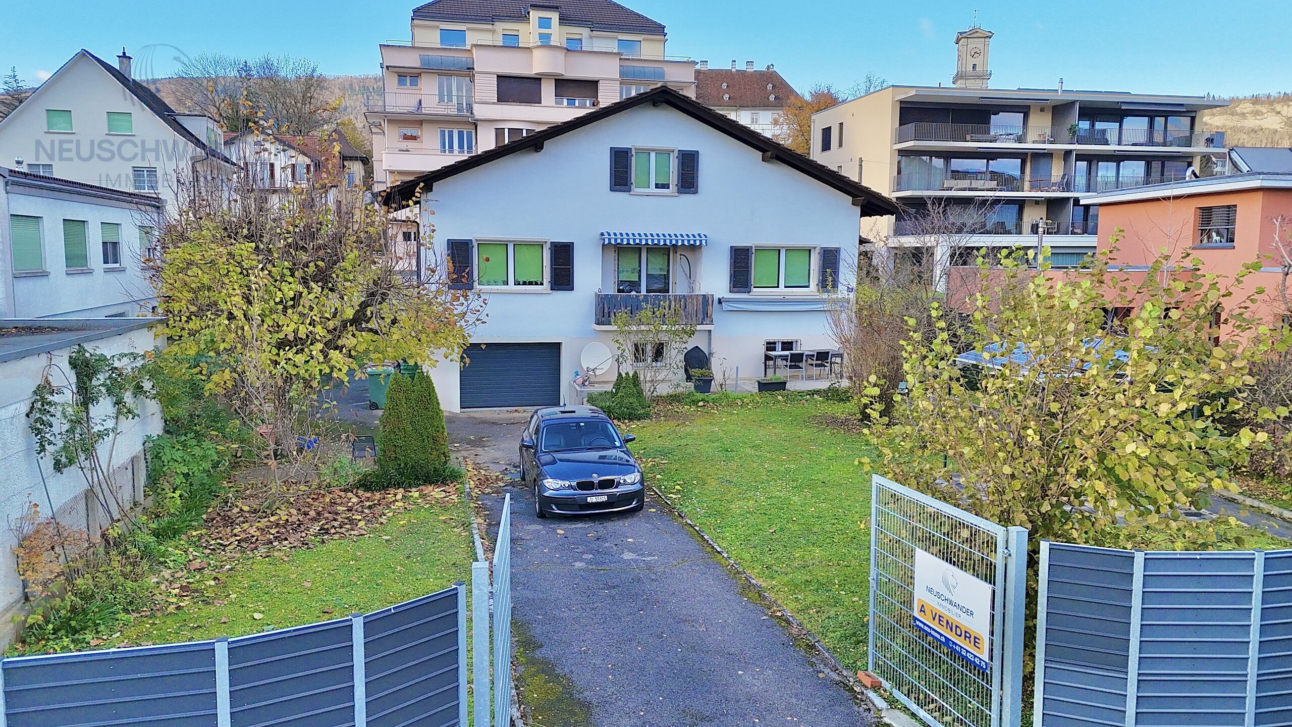 a blue car parked in front of a house