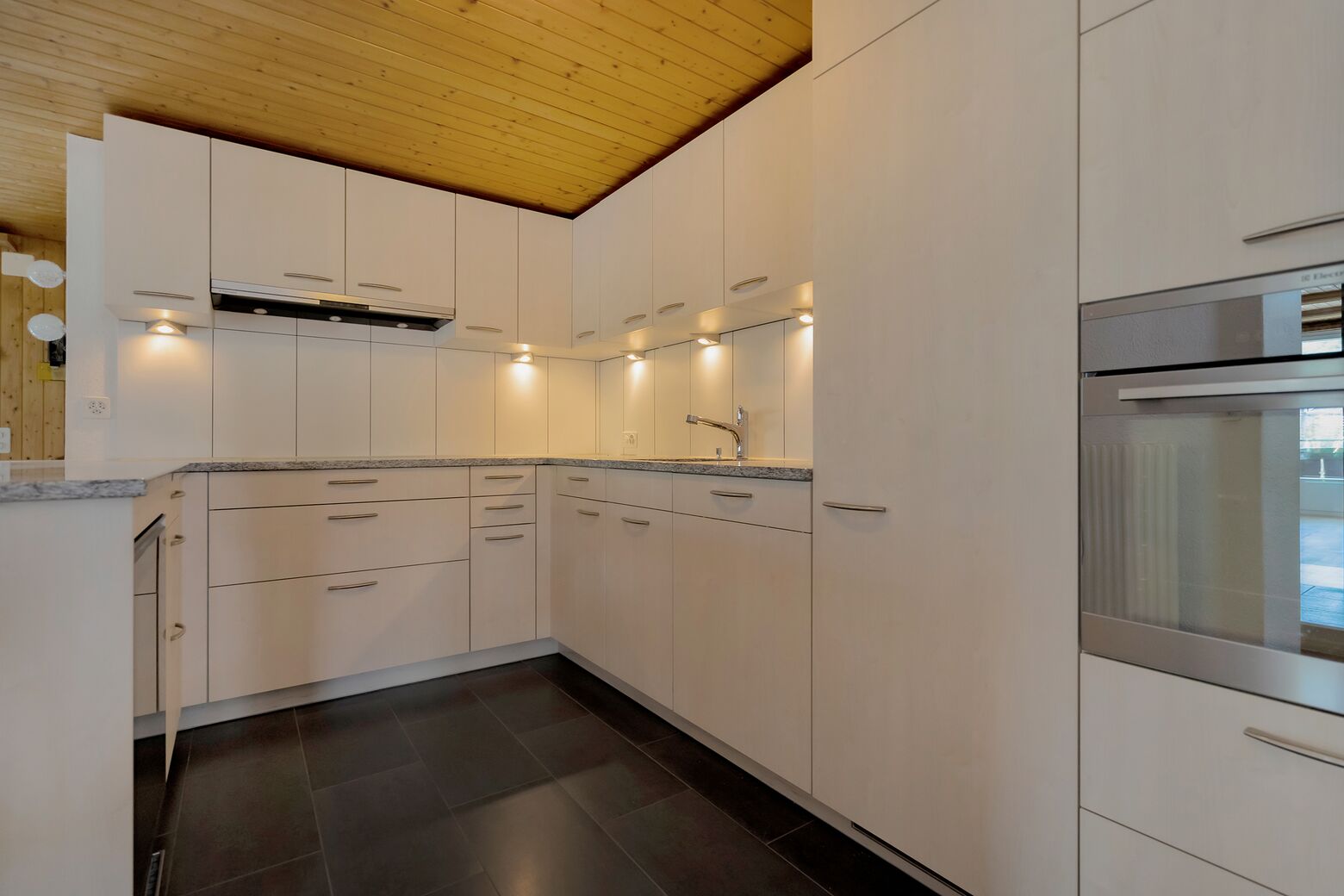 Küche mit Glaskeramikherd, Backofen, Kühlschrank mit Gefrierfach und Geschirrspüler