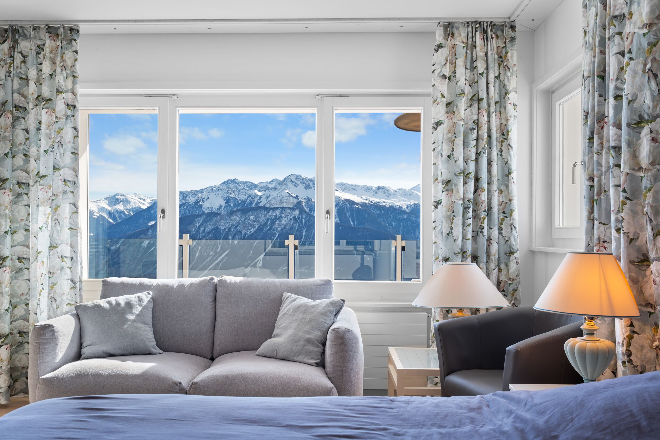 a bedroom with a large window overlooking mountains and a bed