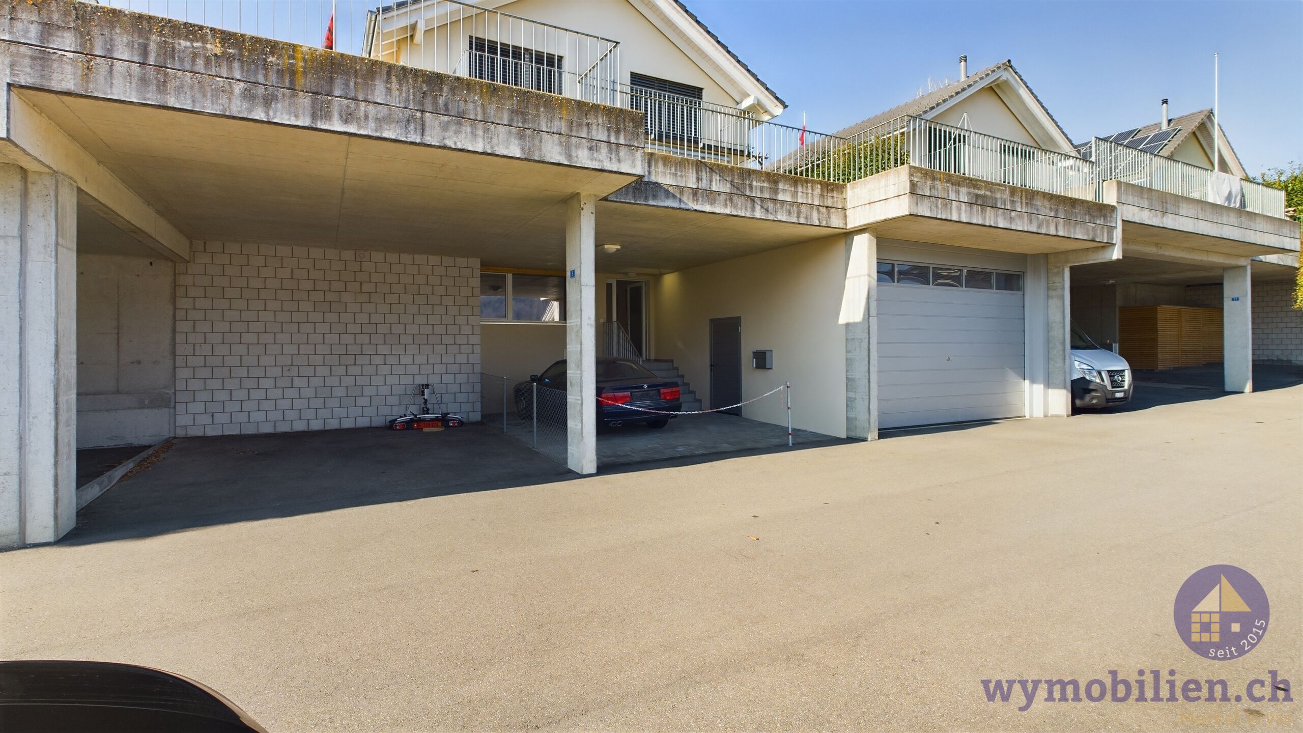 Rechts Doppelgarage, links Aussenparkplatz gedeckt