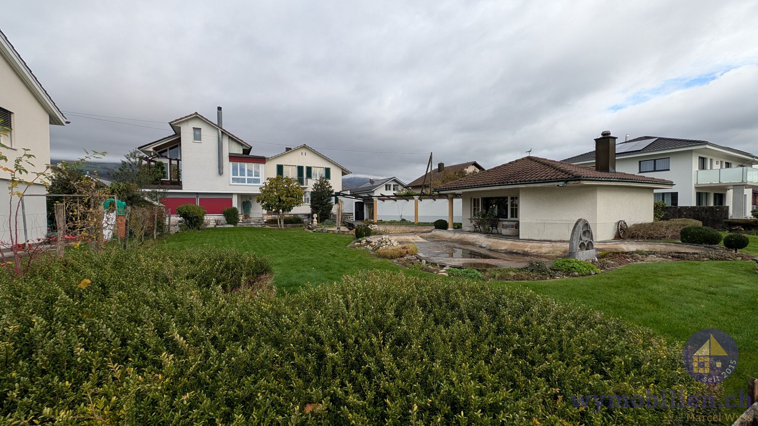Sich auf das Bauland mit Grillhaus und das Haus auf Parzelle 190 (grüne Fensterläden)