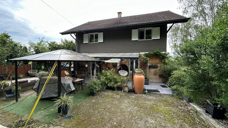 une maison avec un parapluie dans l'arrière-cour