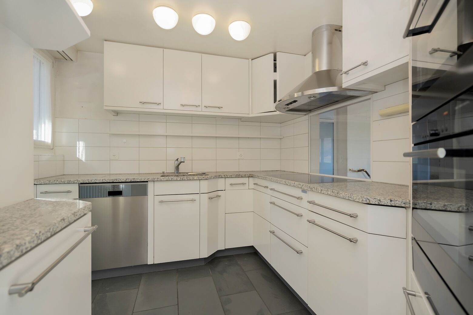 Küche mit Glaskeramikherd, Abwaschmaschine, Kühlschrank, Backofen und Steamer