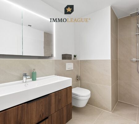 Elegante Badwelten: Hochwertige Materialien definieren das Ambiente im grossen Hauptbad mit Badewanne und Dusche sowie im separaten Gäste-WC. 