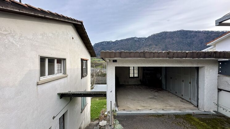 une maison avec des montagnes en arrière-plan