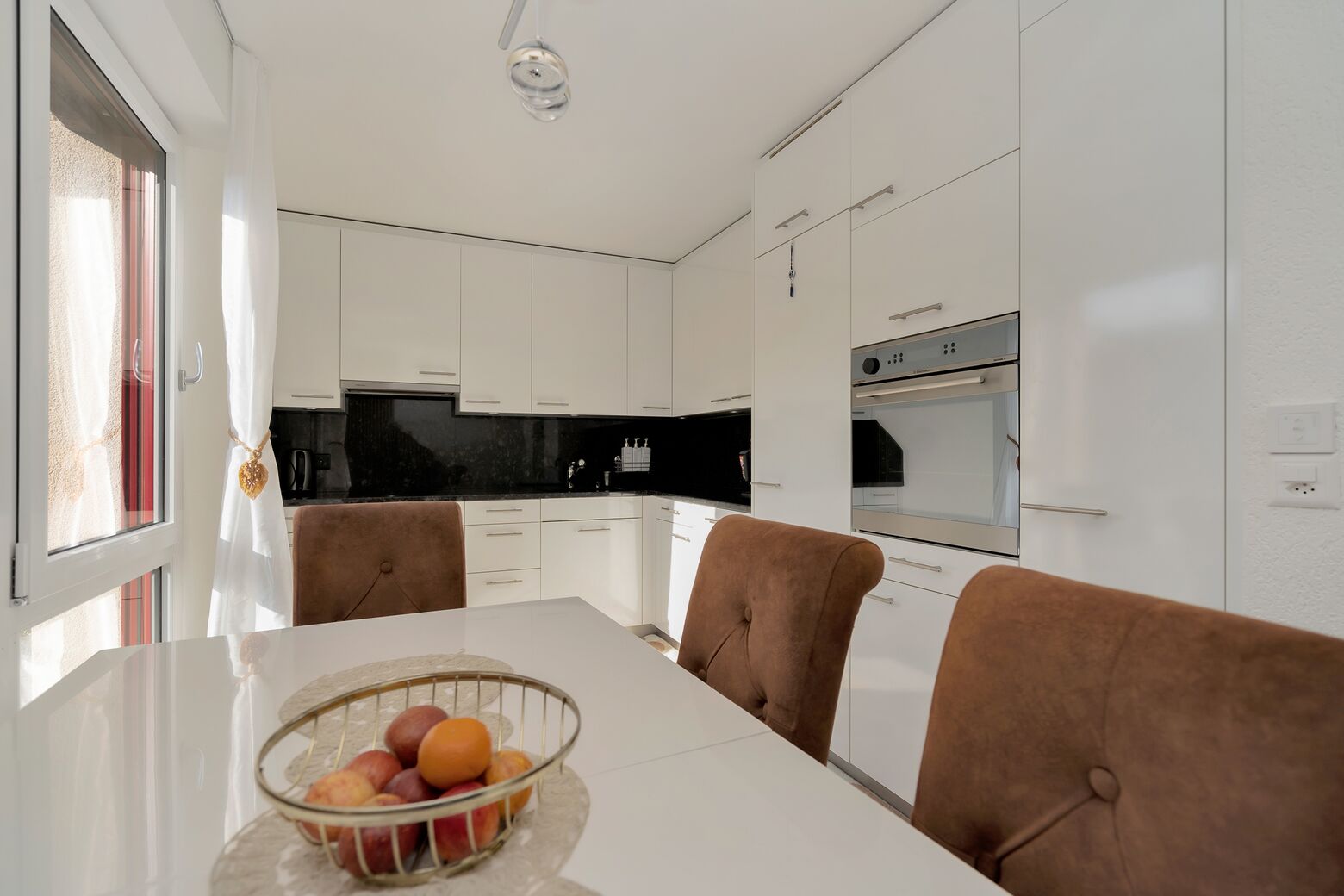 Küche mit Glaskeramikherd, Backofen, Kühlschrank mit Tiefkühlfach, Abwaschmaschine und genügend Stauraum