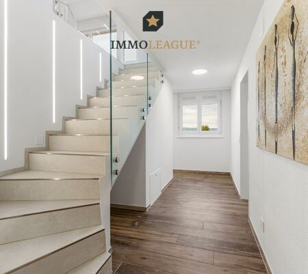 Beleuchtung als Gestaltungselement: Feine LED-Lichtlinien führen die Treppe hinauf. Integrierte Einbauschränke bieten Stauraum, wo man ihn braucht.
