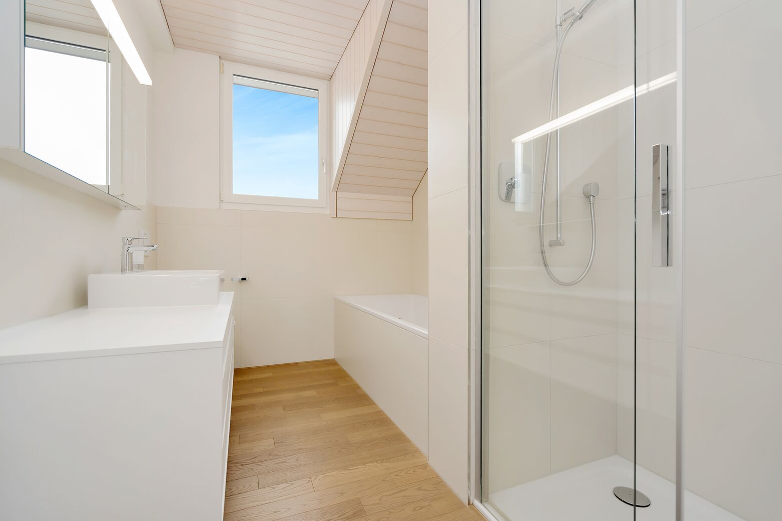 Haupptbad mit Badewanne, Dusche, Toilette, Lavabo und Tageslichtfenster