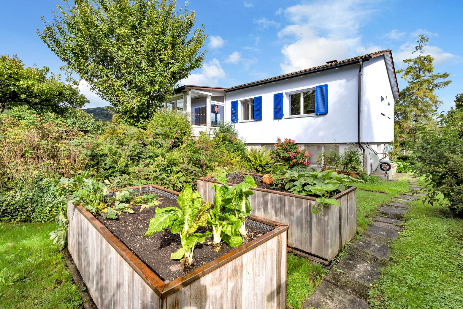 Aussenansicht Süd Fassade und Hochbeete im Gartenbereich