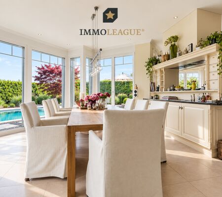 Eine offene Küche mit Essbereich und großen Fenstern bietet den Blick auf ein modernes Haus mit Blick auf den Pool