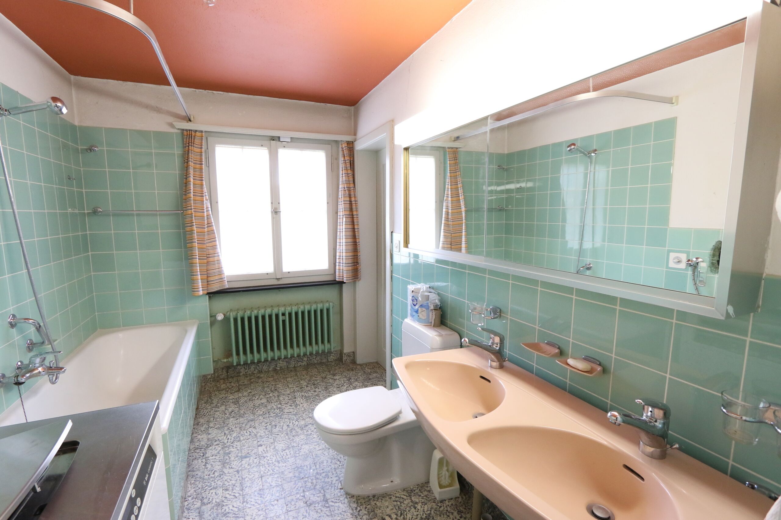 schlichtes Bad mit Badewanne, WC, Doppellavabo und Waschmaschine