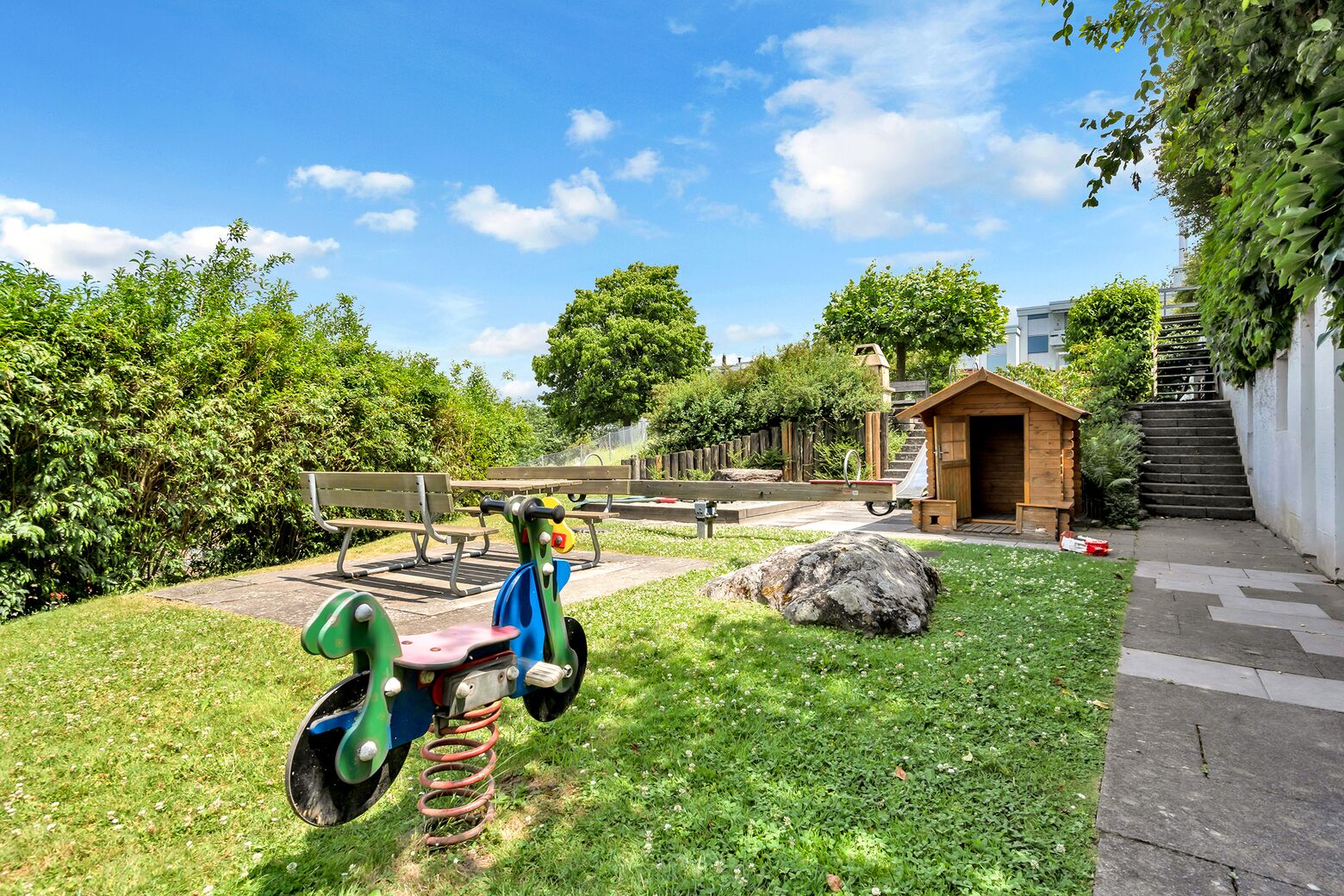 Spielplatz mit Grill und Sitzmöglichkeiten in der Siedlung