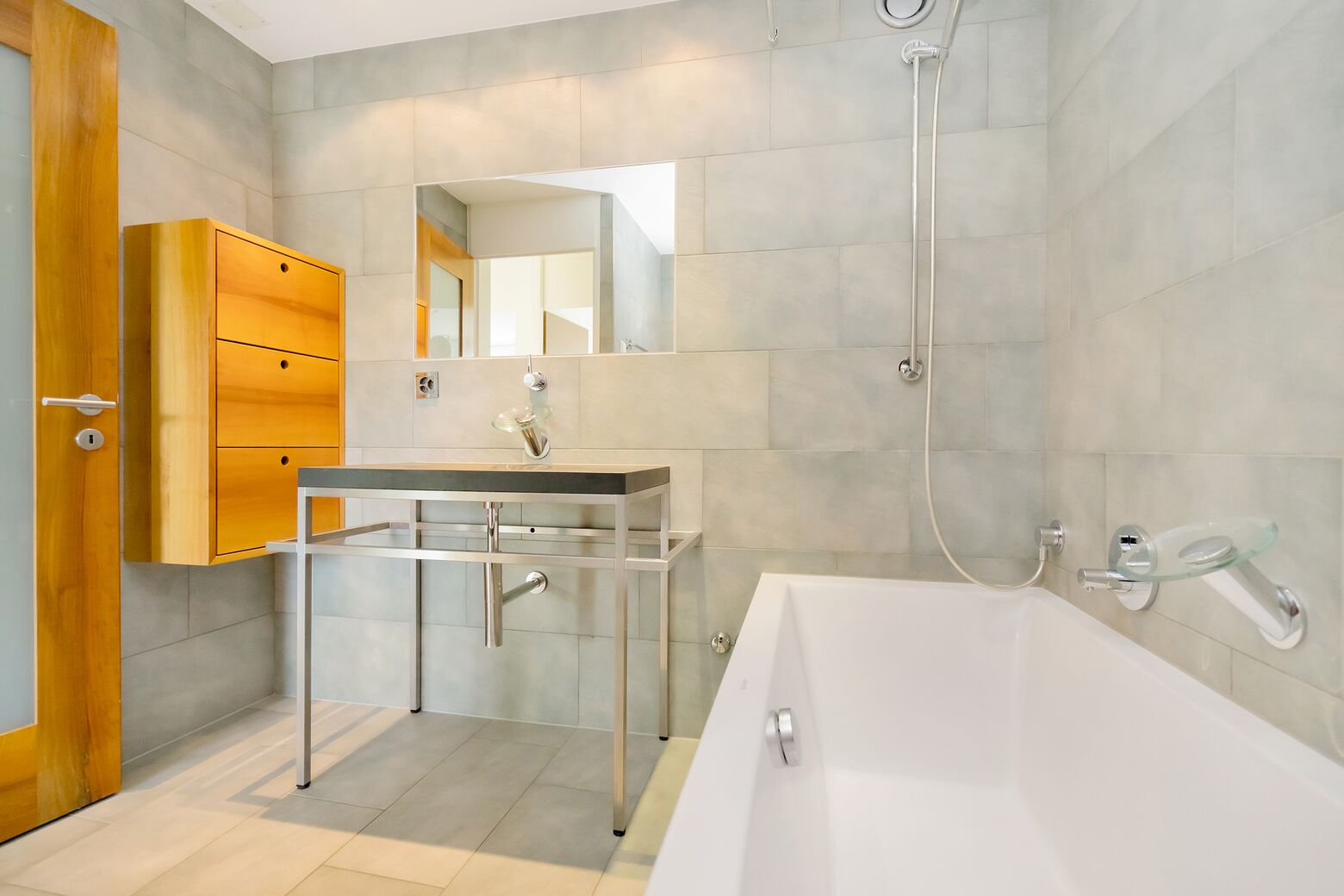 Bad mit Badewanne, Klosett und Waschtisch, Einbaumöbel, raumhohe Plattenbeläge in Keramik