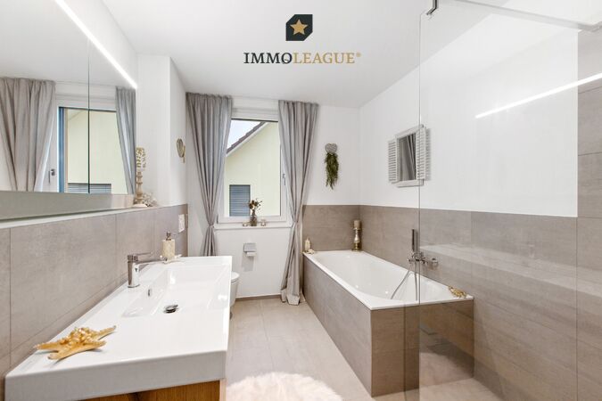 Das helle Bad en Suite besticht durch sein markantes Design.