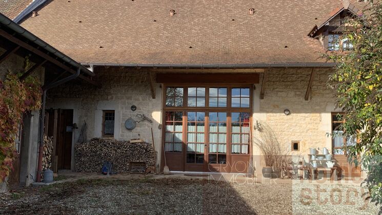 Ferme mitoyenne rénovée avec grand terrain agricole adjacent.