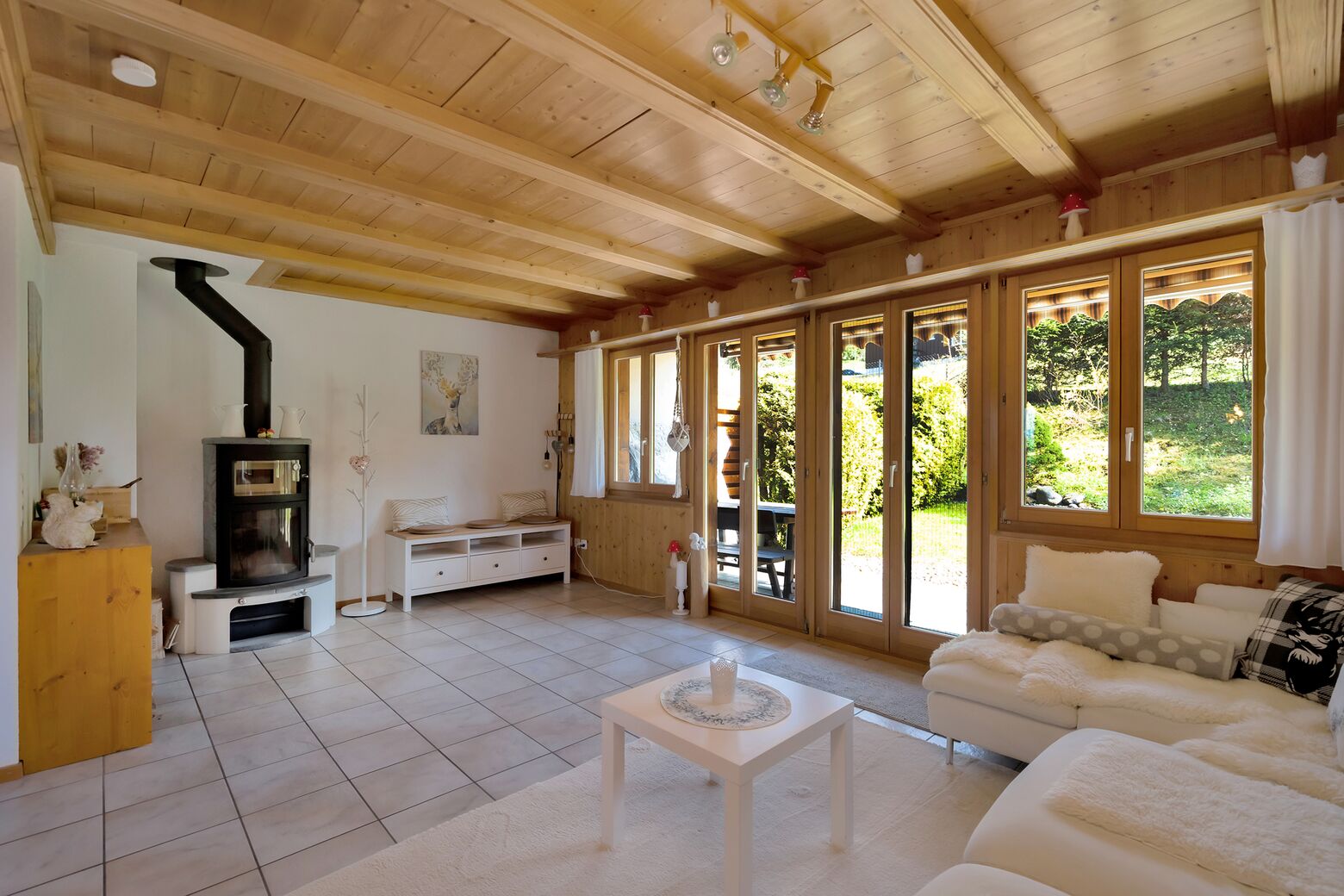 Wohnbereich mit Schwedenofen und Ausgang zum Gartenbereich mit Sitzplatz