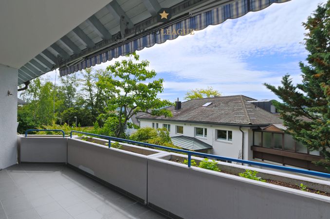 Wohnraum mit sonnigem Balkon und Blick ins Grün