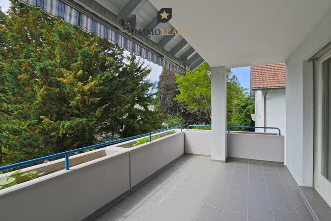 Wohnraum mit sonnigem Balkon und Blick ins Grün
