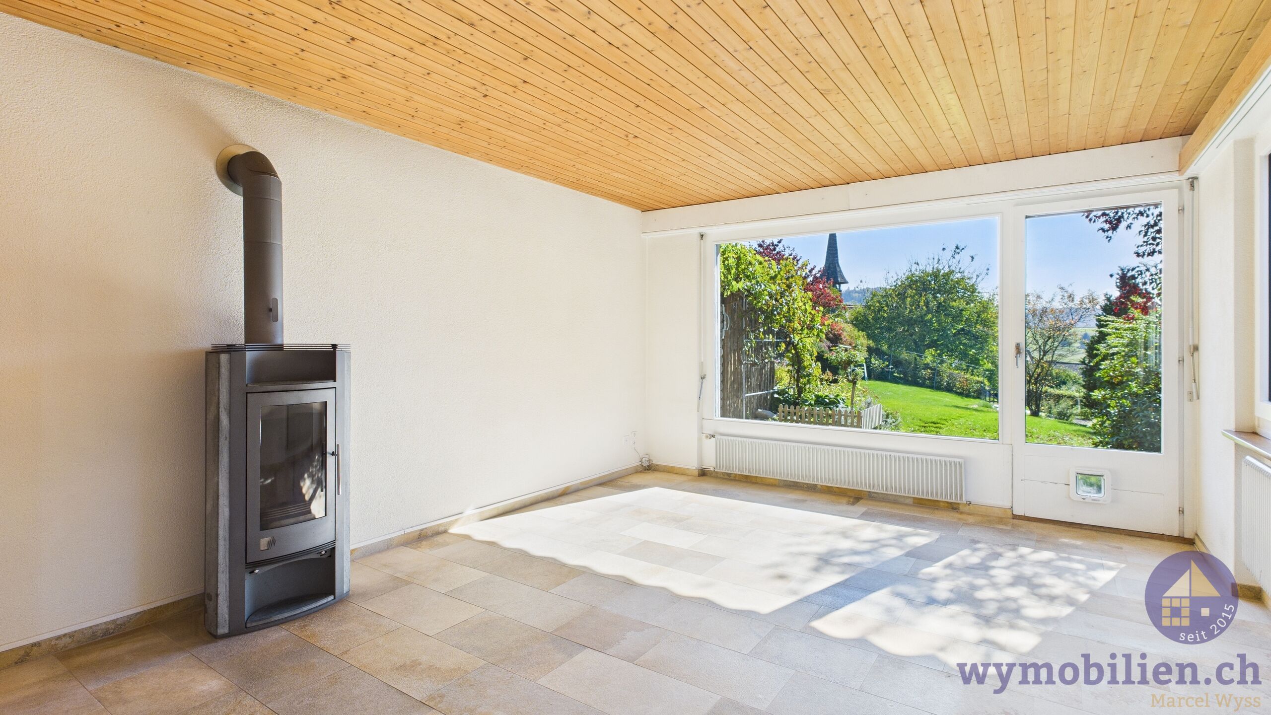 Wohnzimmer mit Cheminéeofen und Ausgang auf den Sitzplatz