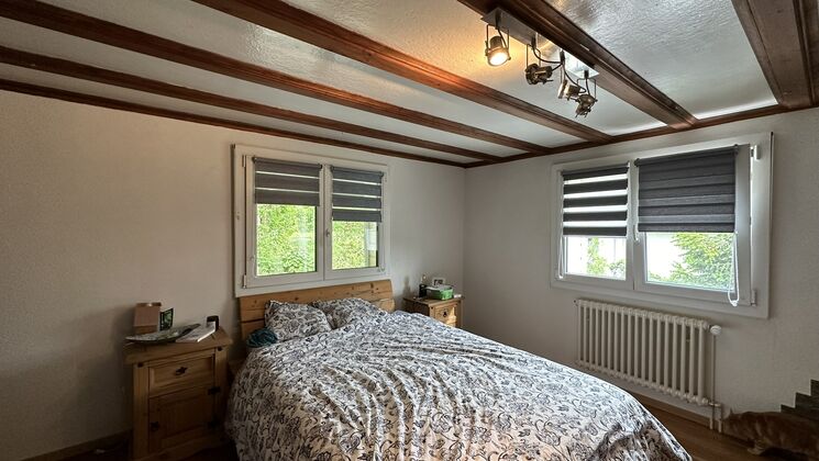 une chambre avec un grand lit et un plafond incliné