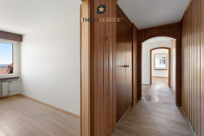 Warme Holzelemente verleihen dem geräumigen Flur mit Einbauschrank ein gemütliches Flair.