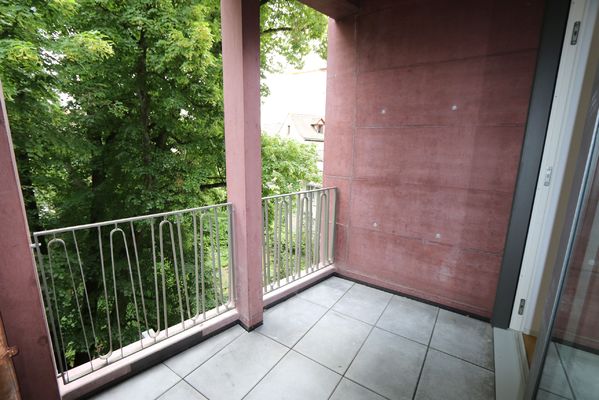 lauschiger, gedeckter Balkon mit Blick in den Park