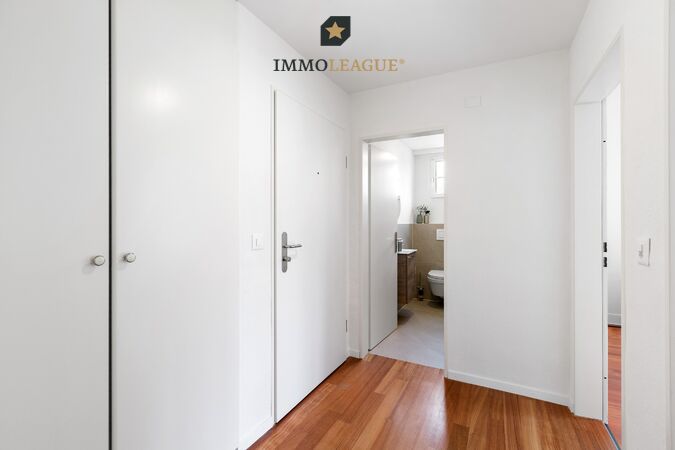Heller Eingangsbereich mit praktischem Einbauschrank und hochwertigem Parkettboden.