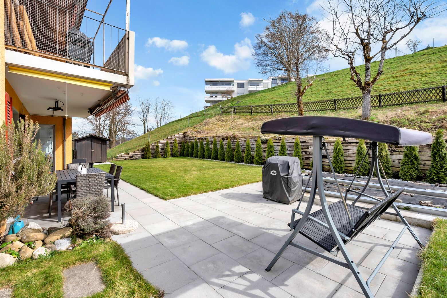 Gut besonnter Gartenbereich mit Sitzplatz und Gartenbeete