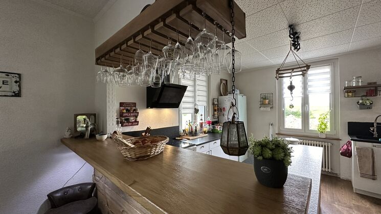 une cuisine avec un bar et une table en bois