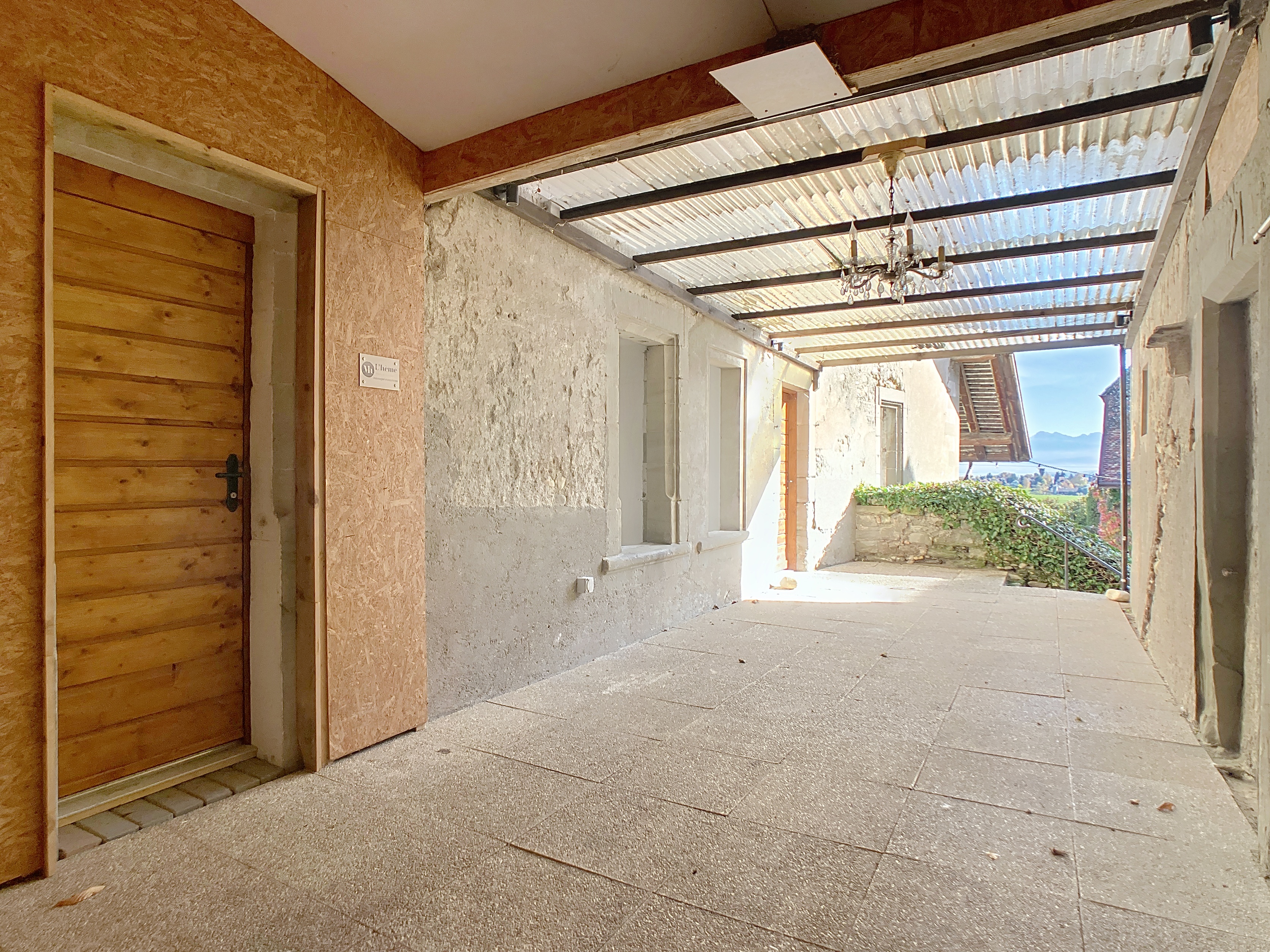 Terrasse couverte devant l'entrée et accès au jardin