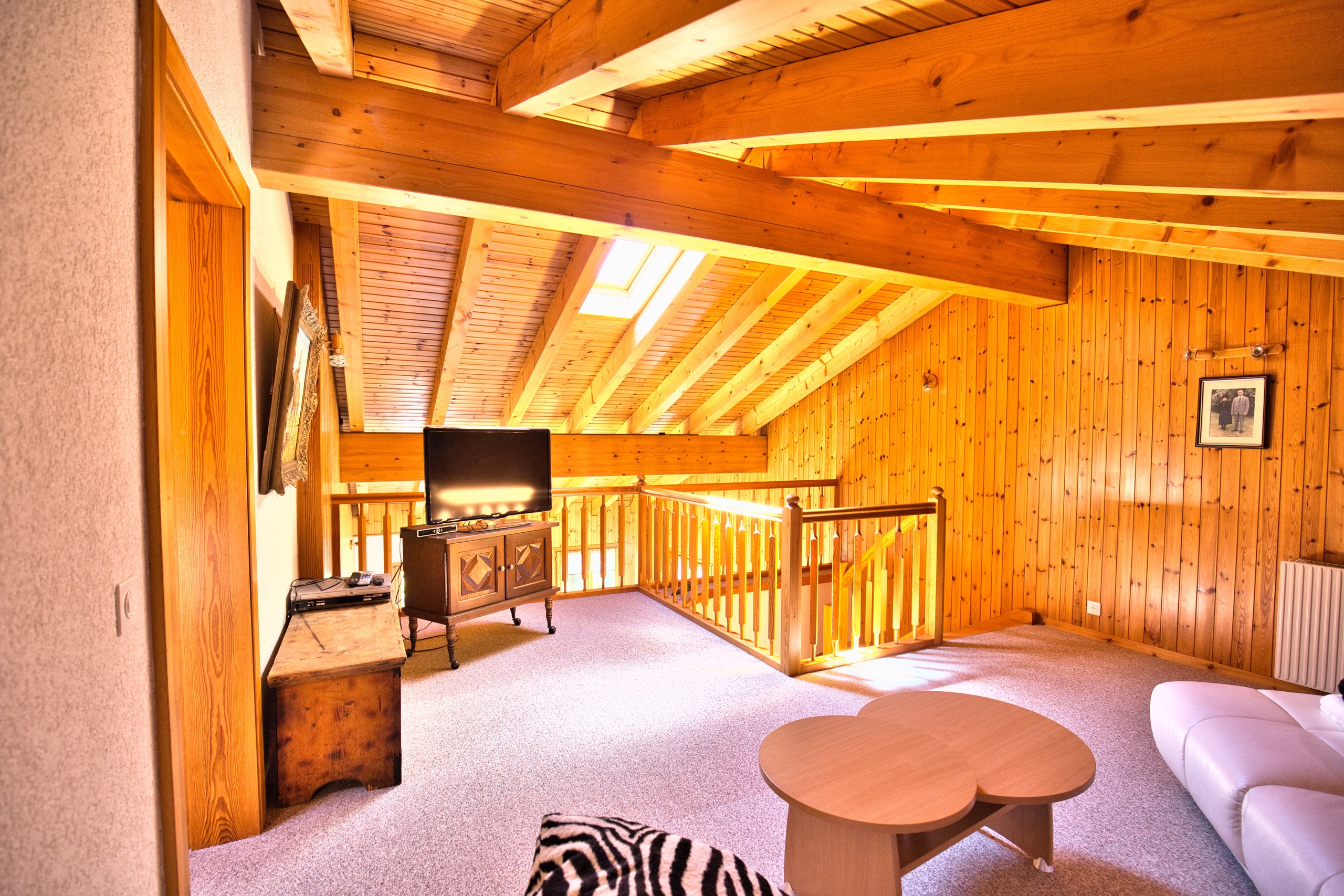 une grande pièce avec des murs et un plafond en bois, un canapé et une table une grande pièce avec des murs et un plafond en bois, un canapé et une table