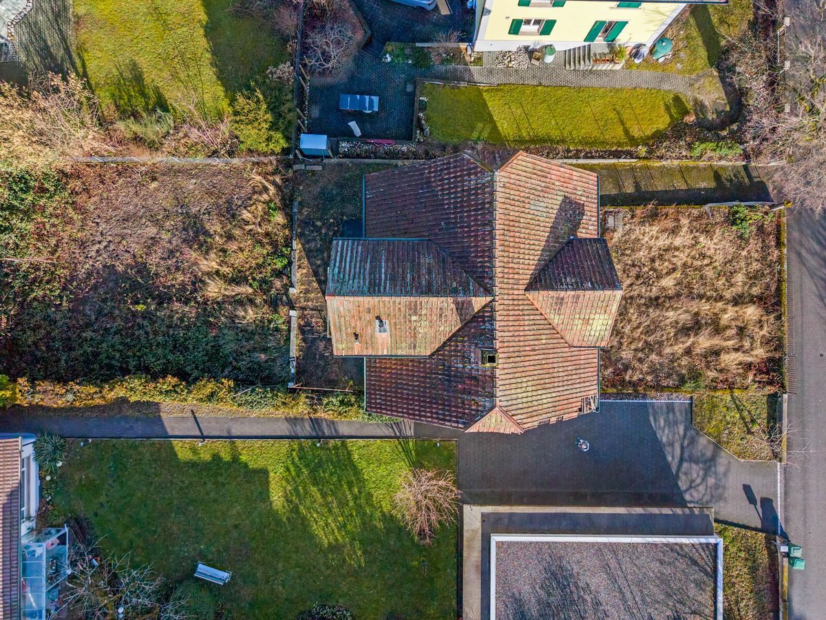Luftaufnahme eines Wohngebäudes mit Garten und Zufahrt.