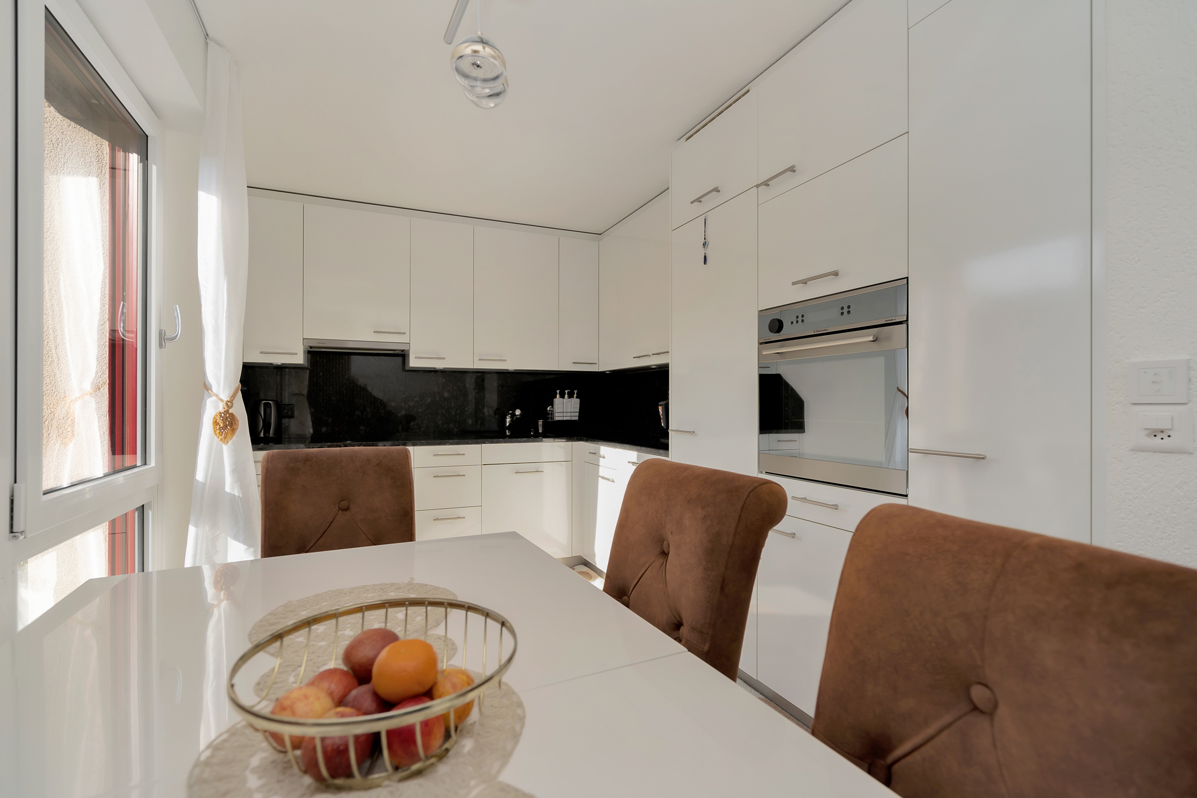 Küche mit Glaskeramikherd, Backofen, Kühlschrank mit Tiefkühlfach, Abwaschmaschine und genügend Stauraum