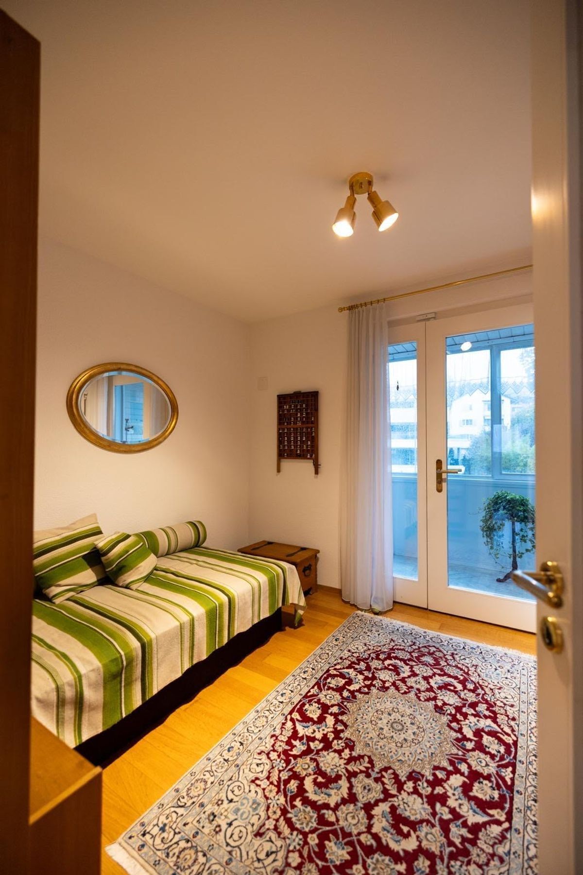 Gemütliches Zimmer mit Tagesbett und direktem Balkonzugang.