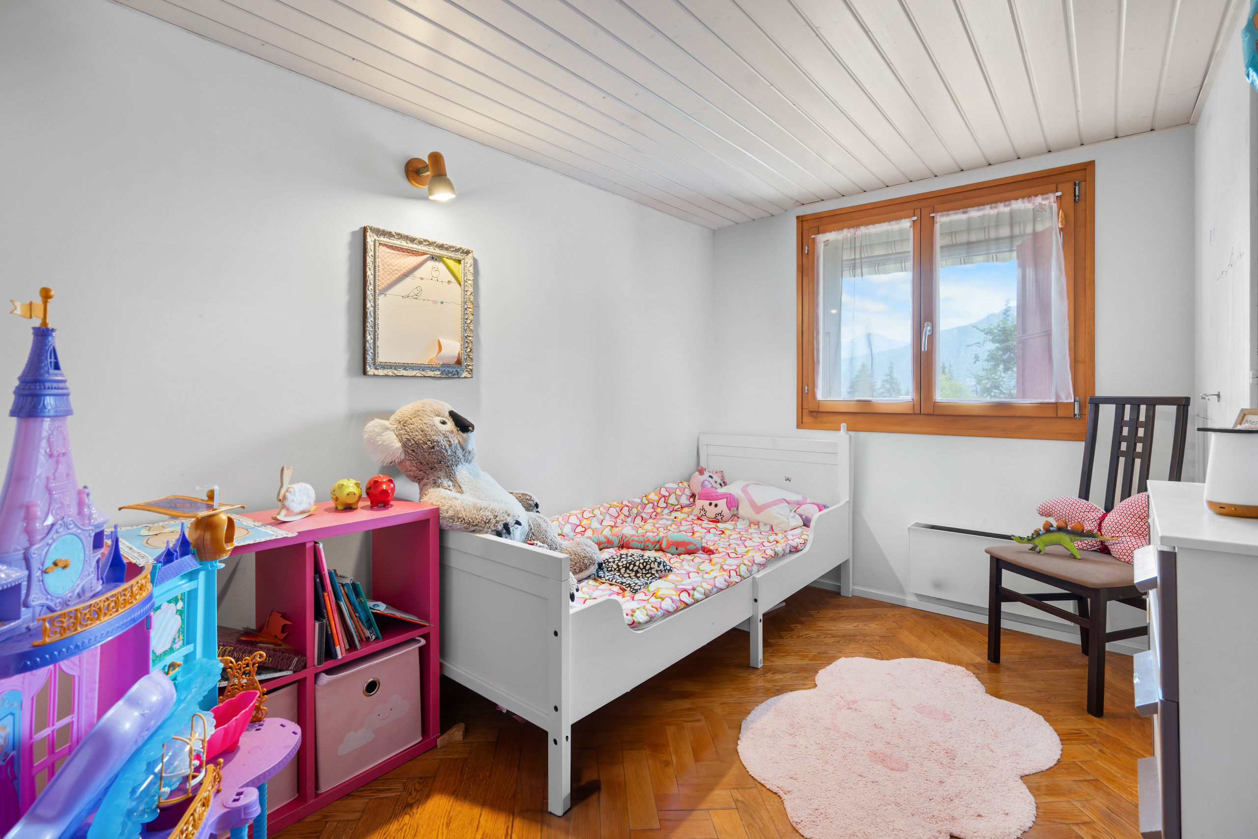 une chambre d'enfant avec un lit blanc et un couvre-lit rose une chambre d'enfant avec un lit blanc et un couvre-lit rose