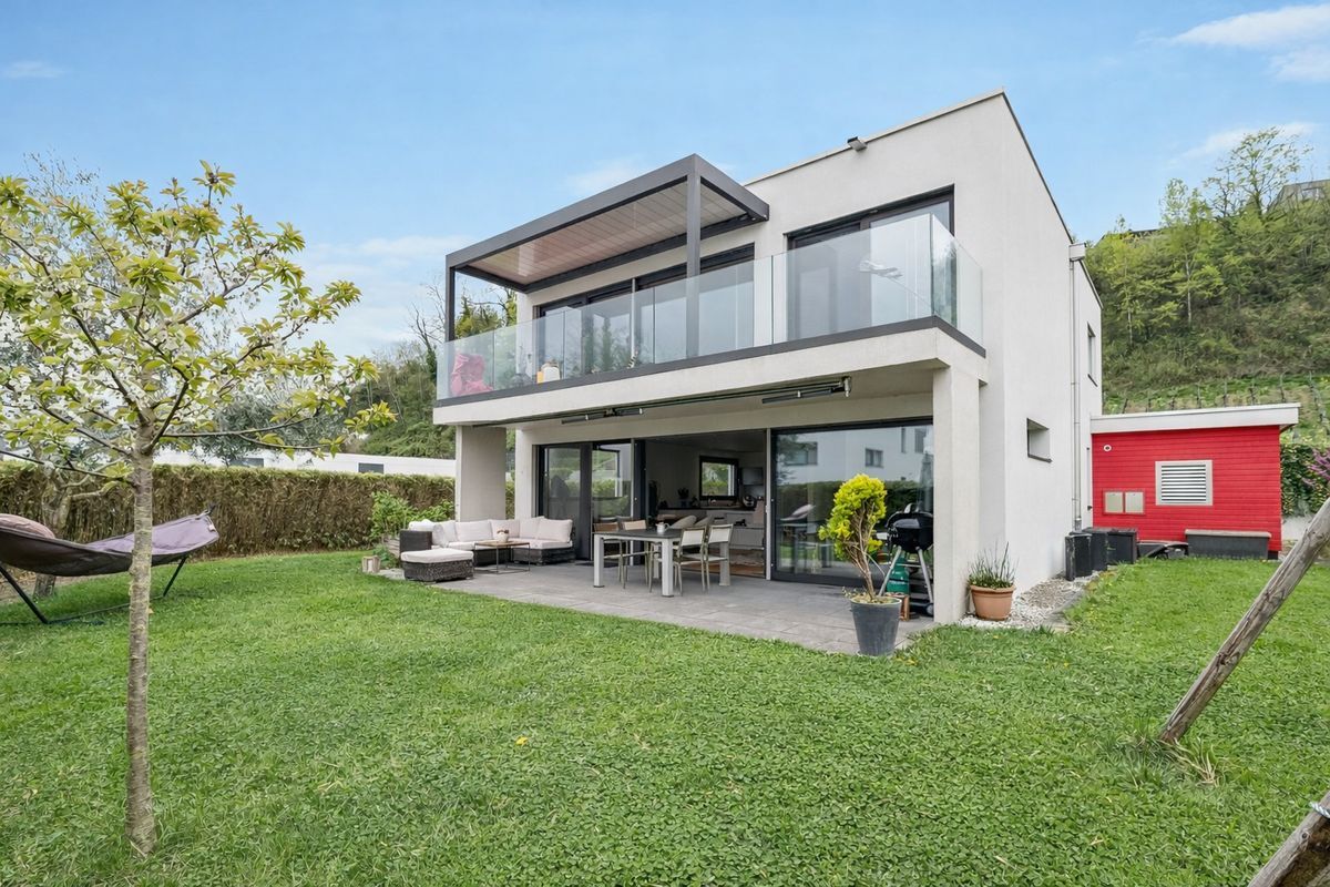 Espace extérieur avec terrasse couverte et coin salon.