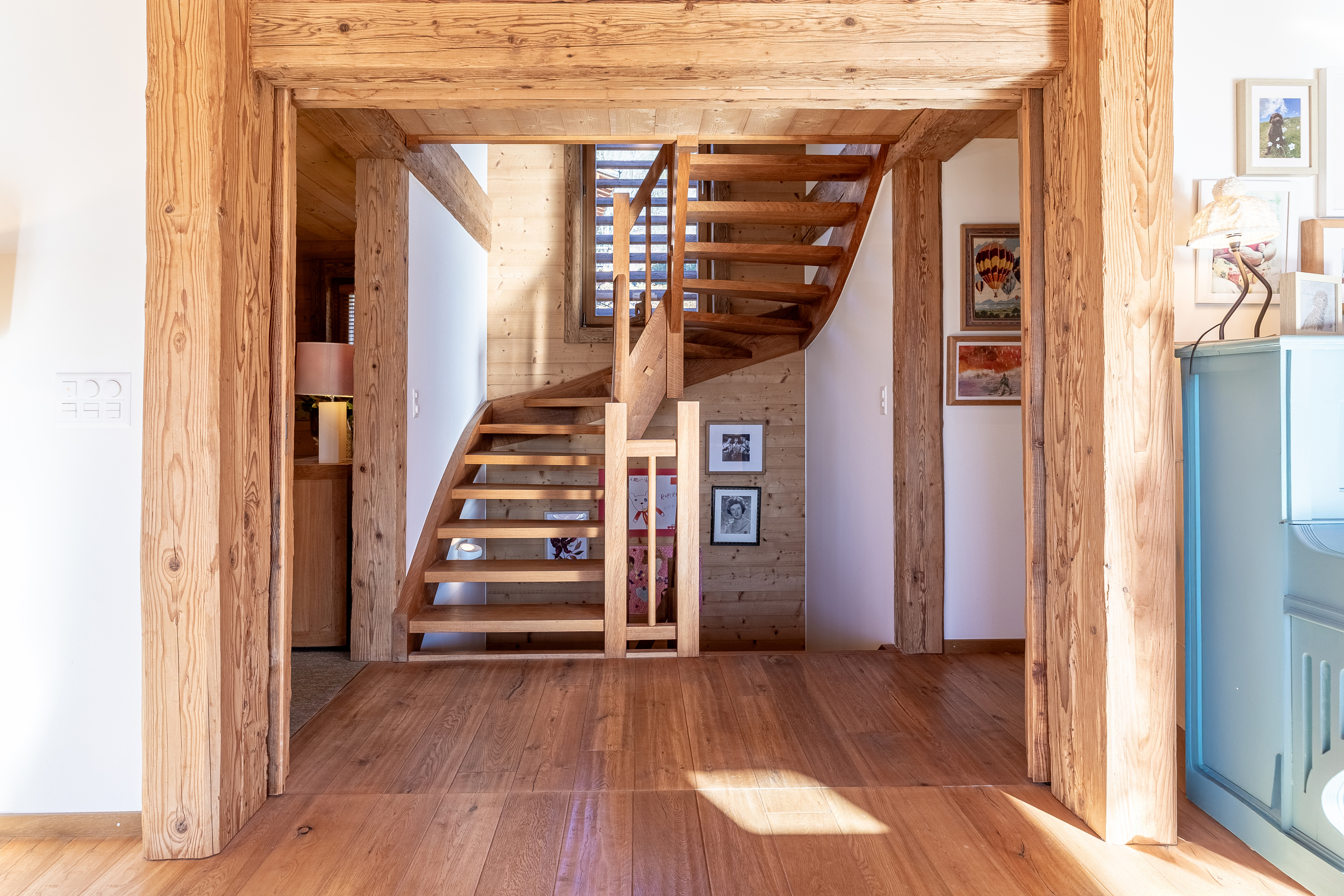 un escalier en bois mène au deuxième étage d'une maison comprenant une cuisine et une buanderie