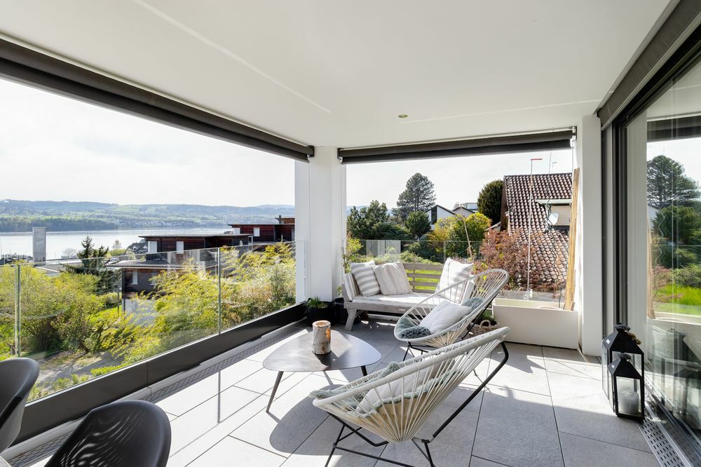 das Wohnzimmer eines modernen Hauses mit großen Fenstern und Blick auf einen See das Wohnzimmer eines modernen Hauses mit großen Fenstern und Blick auf einen See