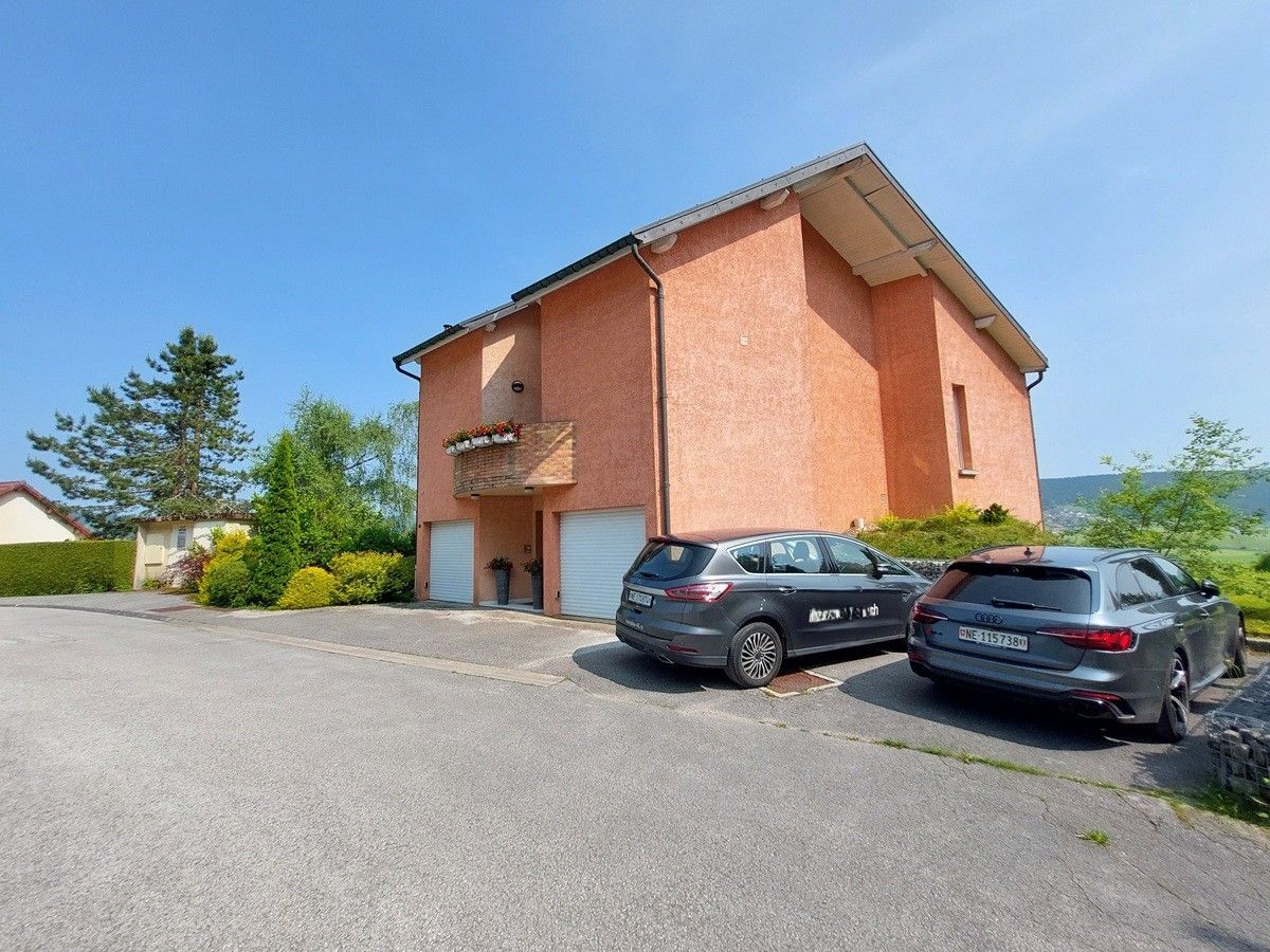 Vue de la villa avec deux garages et stationnement.