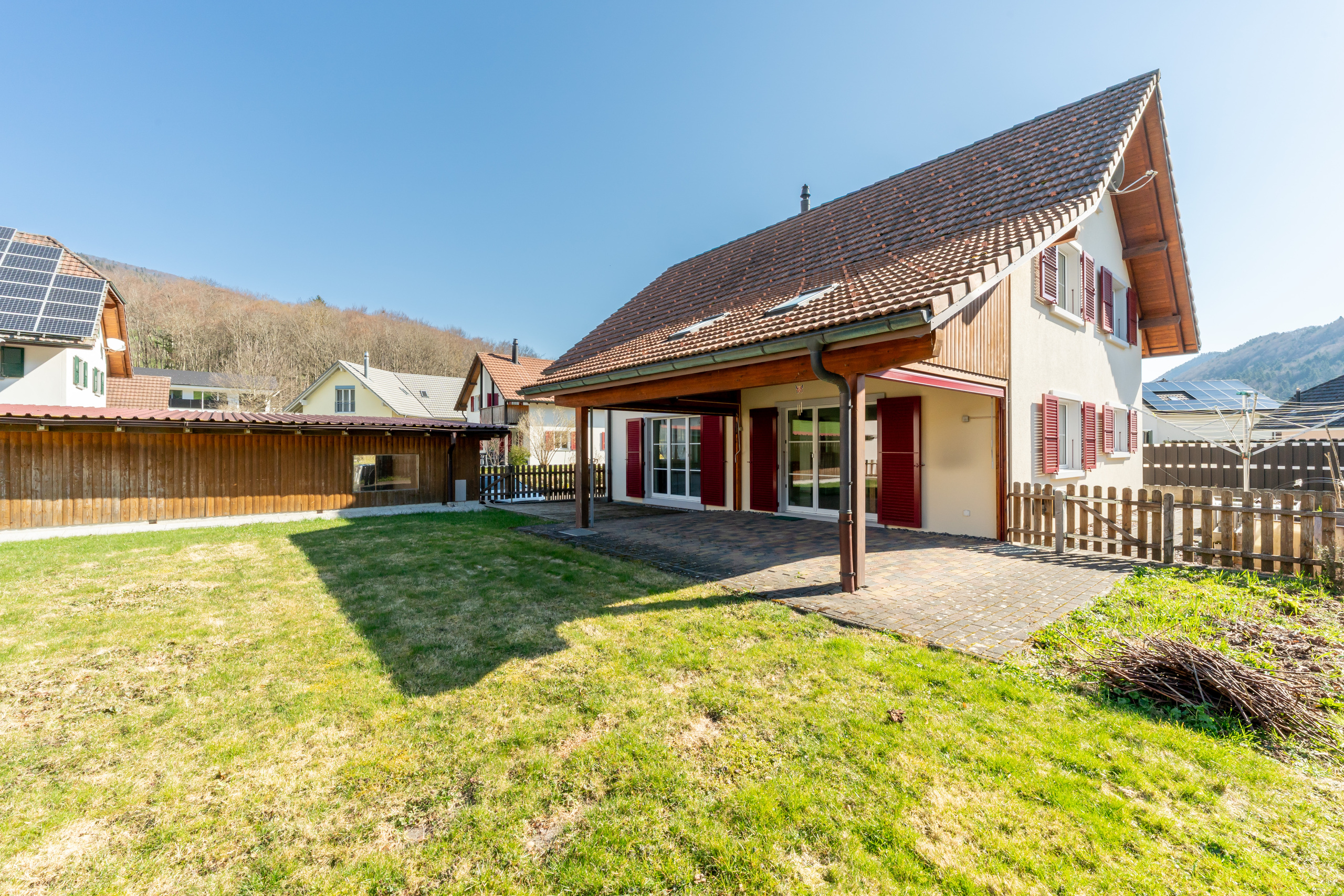 Grosszügige Grünfläche mit gedecktem Sitzplatz zum Entspannen und Verweilen