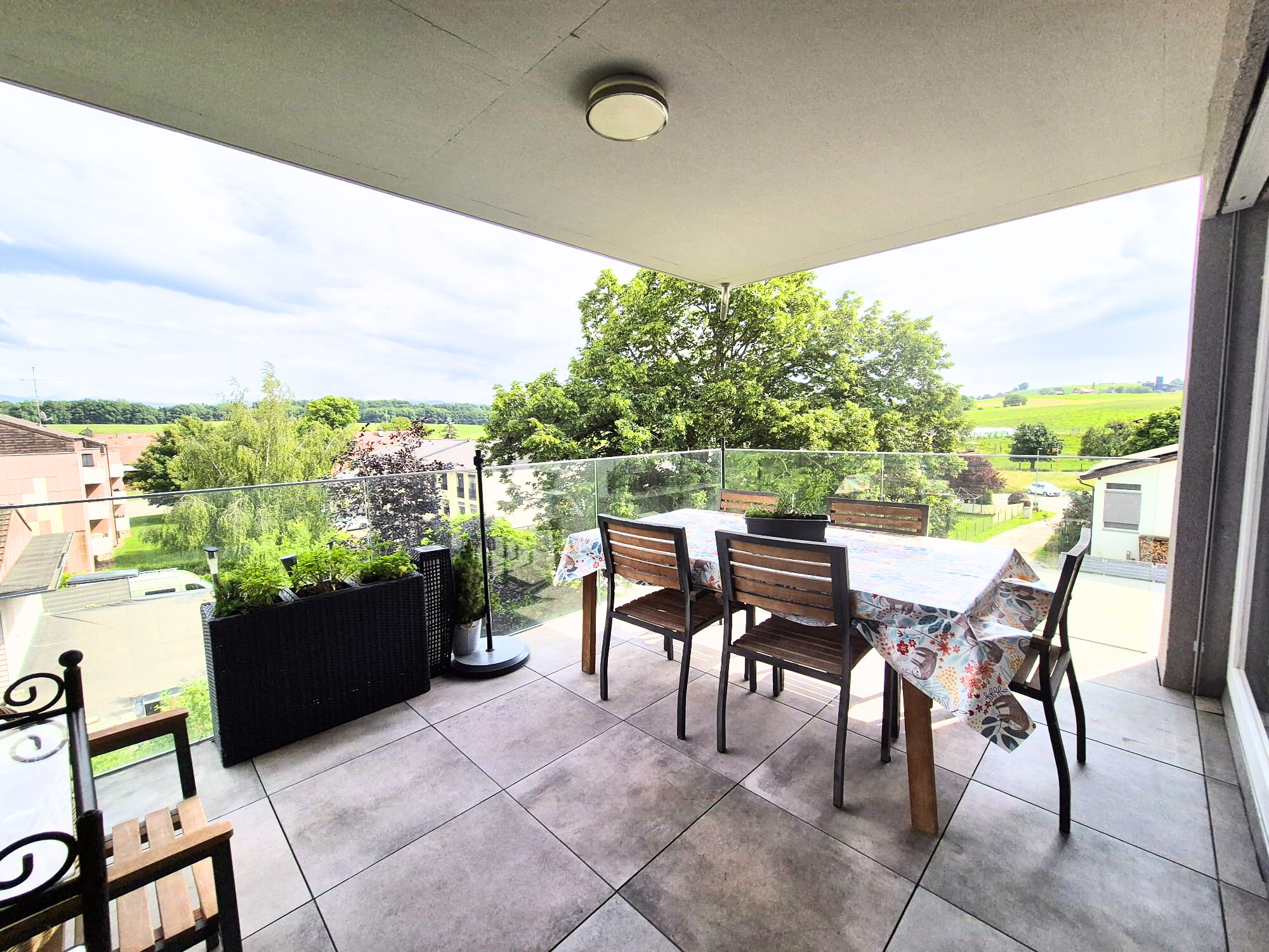 un grand balcon avec table et chaises