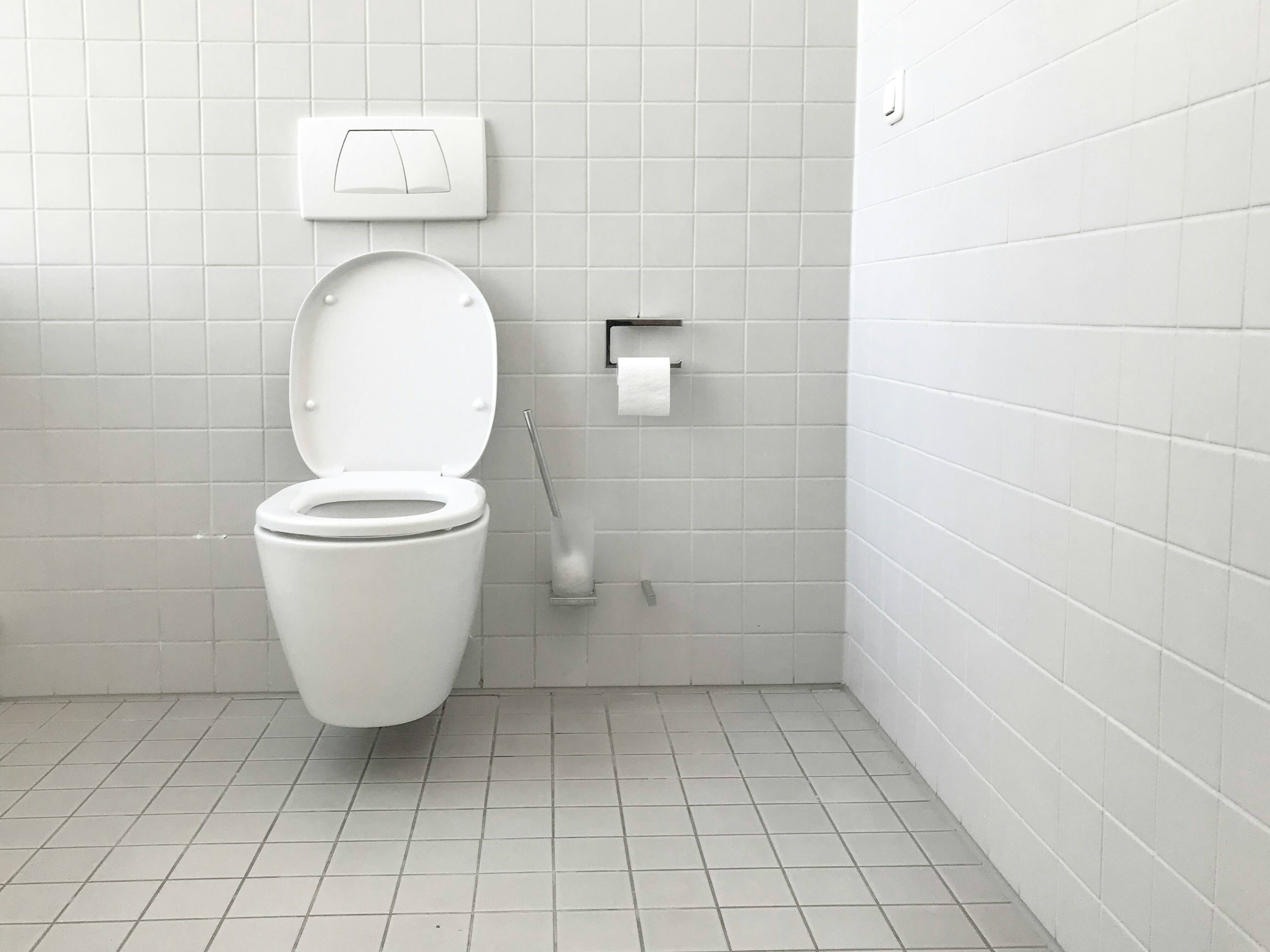 des toilettes avec des murs et des sols en carrelage blanc et des toilettes dans la cabine des toilettes avec des murs et des sols en carrelage blanc et des toilettes dans la cabine