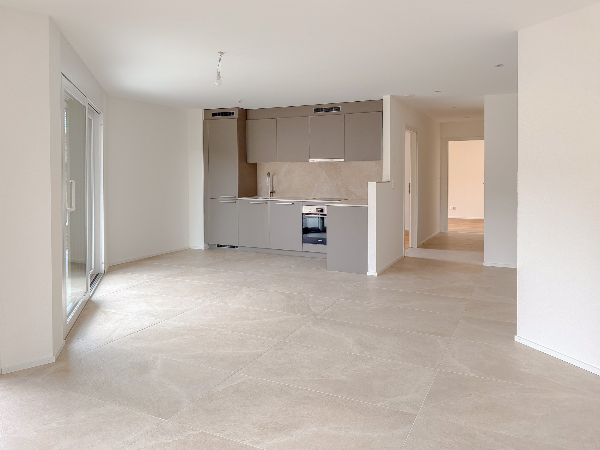 Espace salon/séjour avec portes-fenêtres donnant accès à la terrasse et au jardin privatif