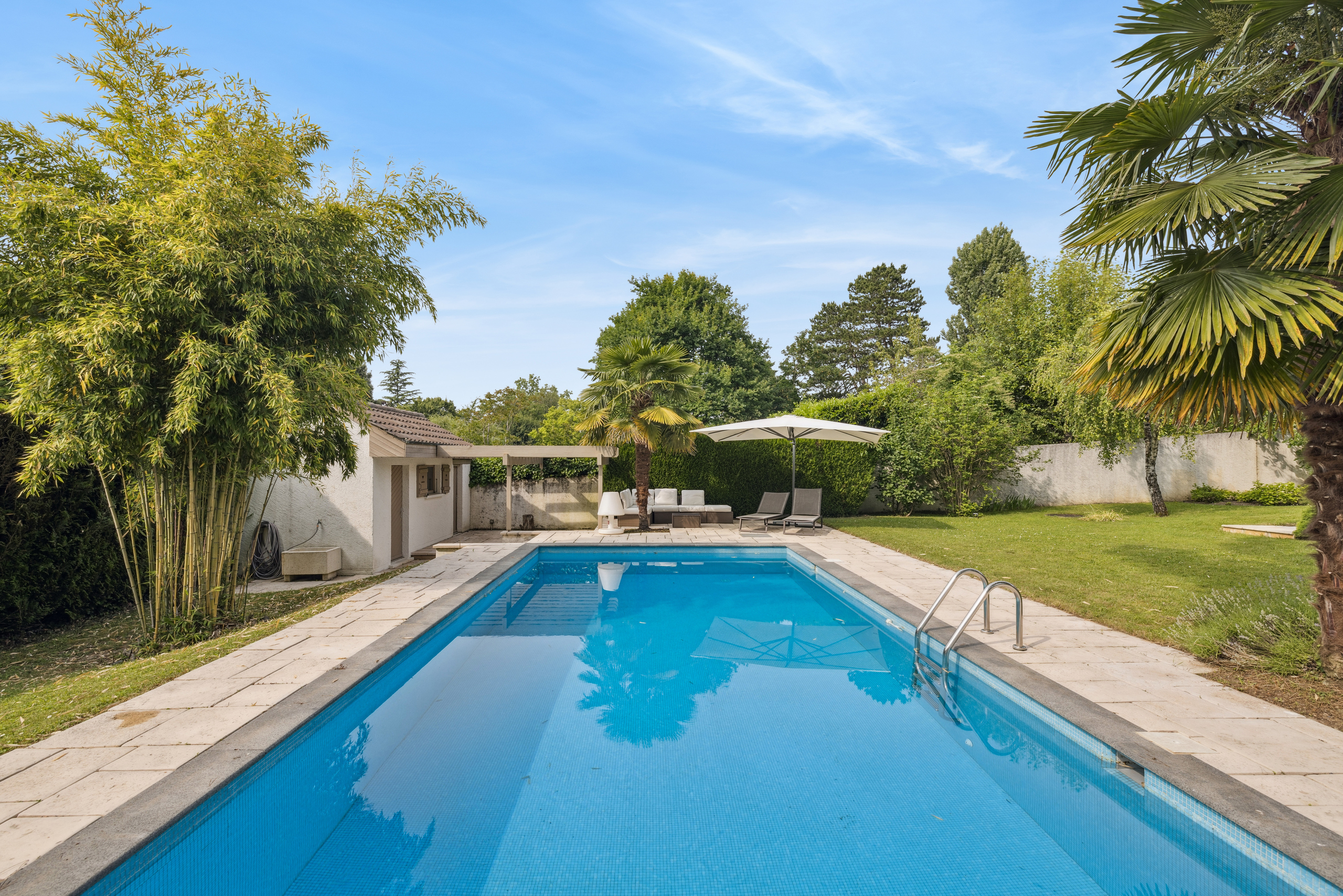 Großer Pool mit Terrasse und Poolhaus