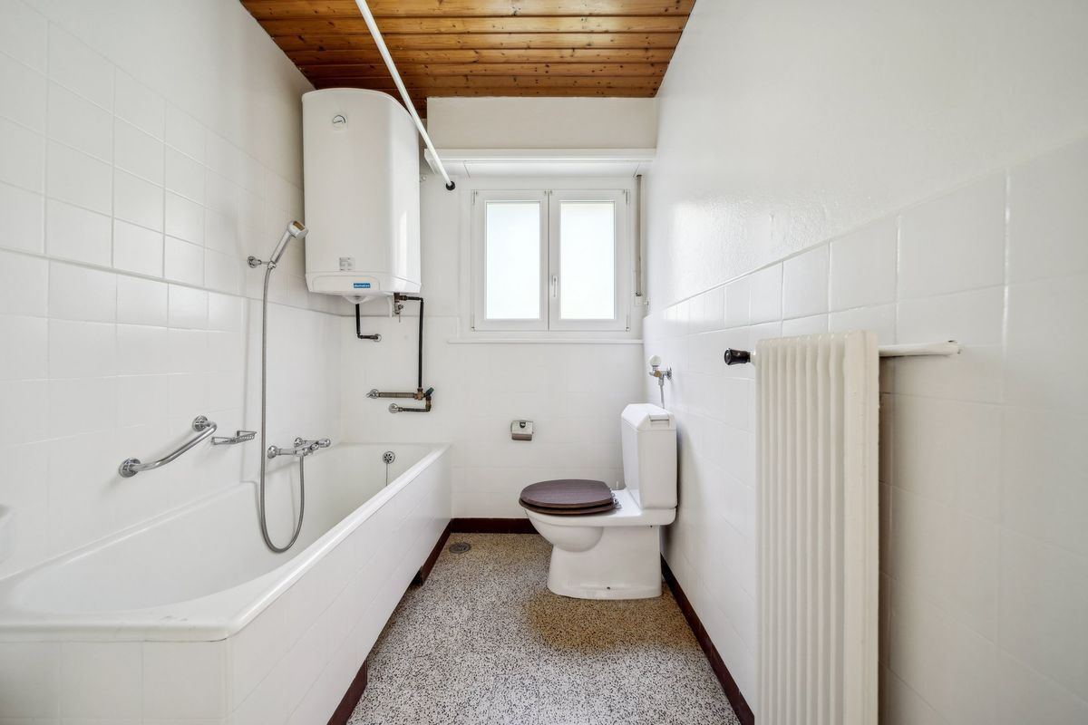 Salle de bain équipée d'une baignoire et d'un chauffe-eau moderne.