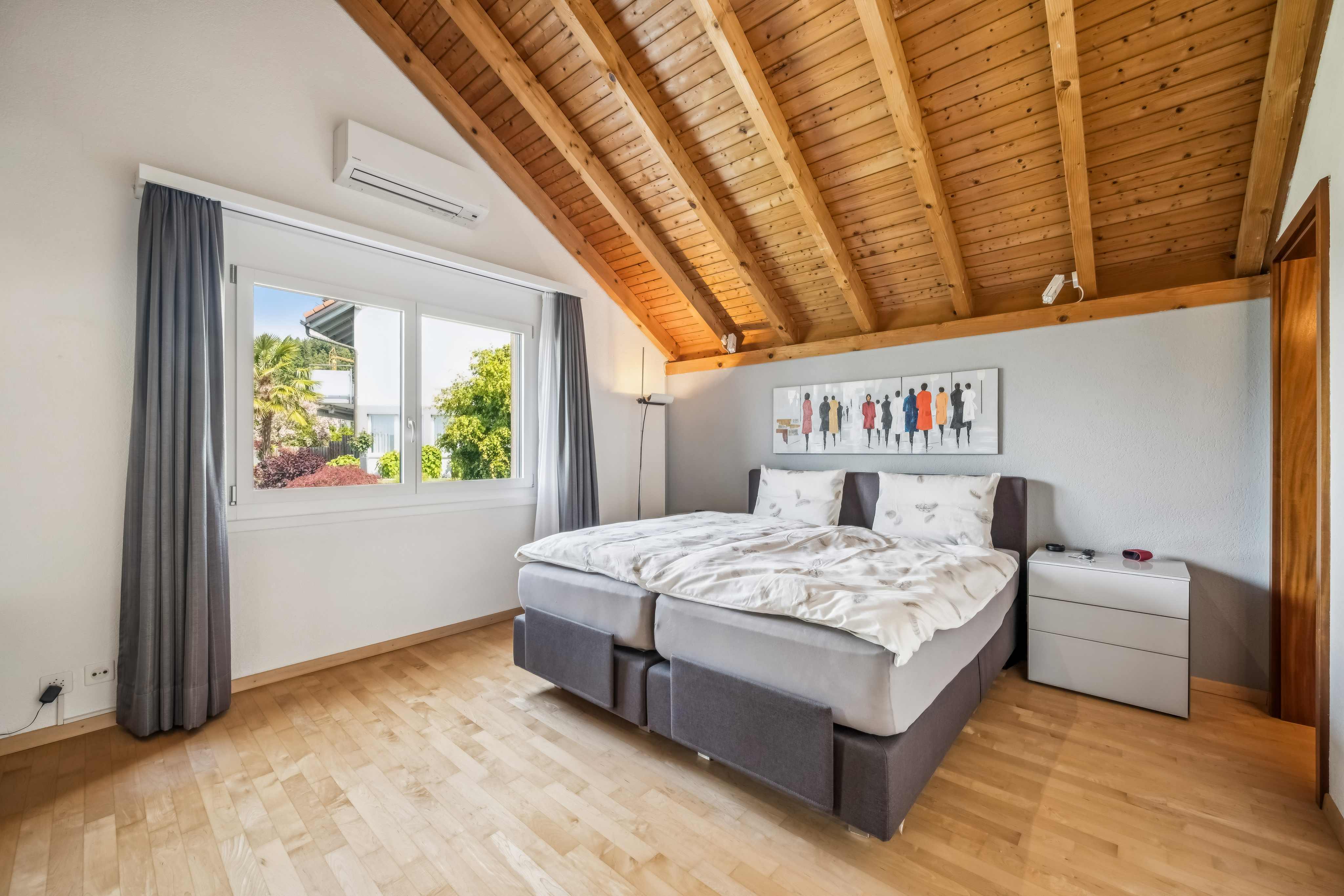 Schlafzimmer mit grosszügigem Fenster und Bad en suite.