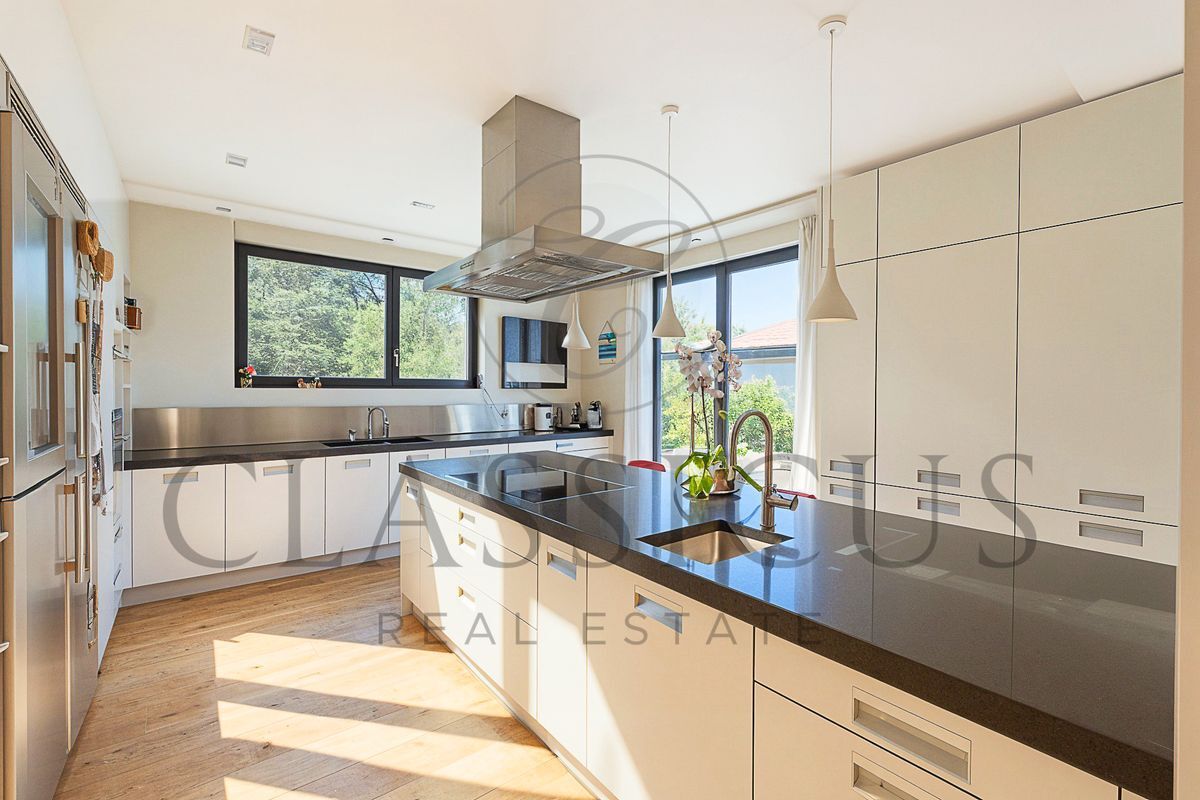 Cuisine moderne avec îlot central et vue extérieure.