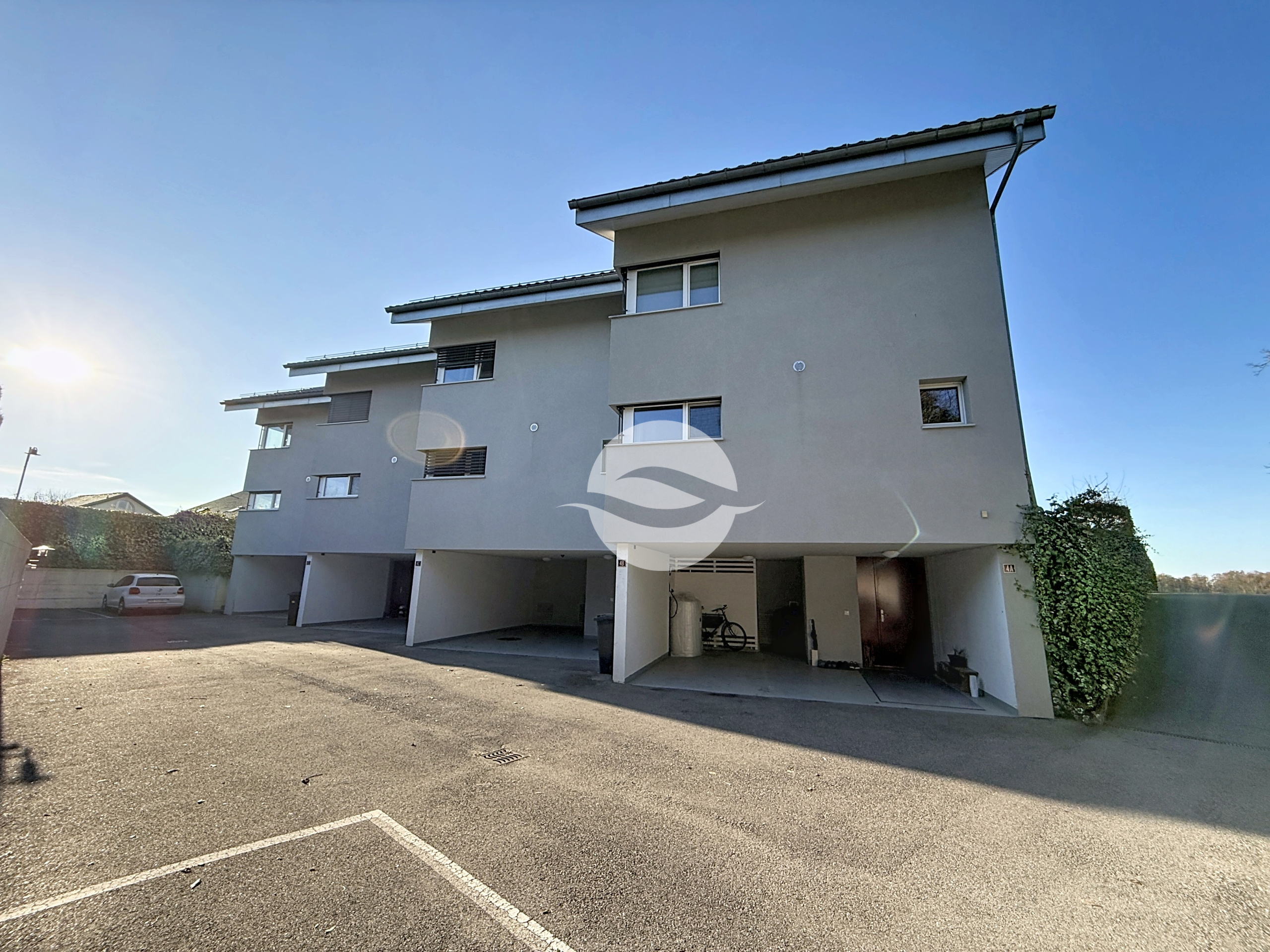 Extérieur : côté entrée et place de parc couverte