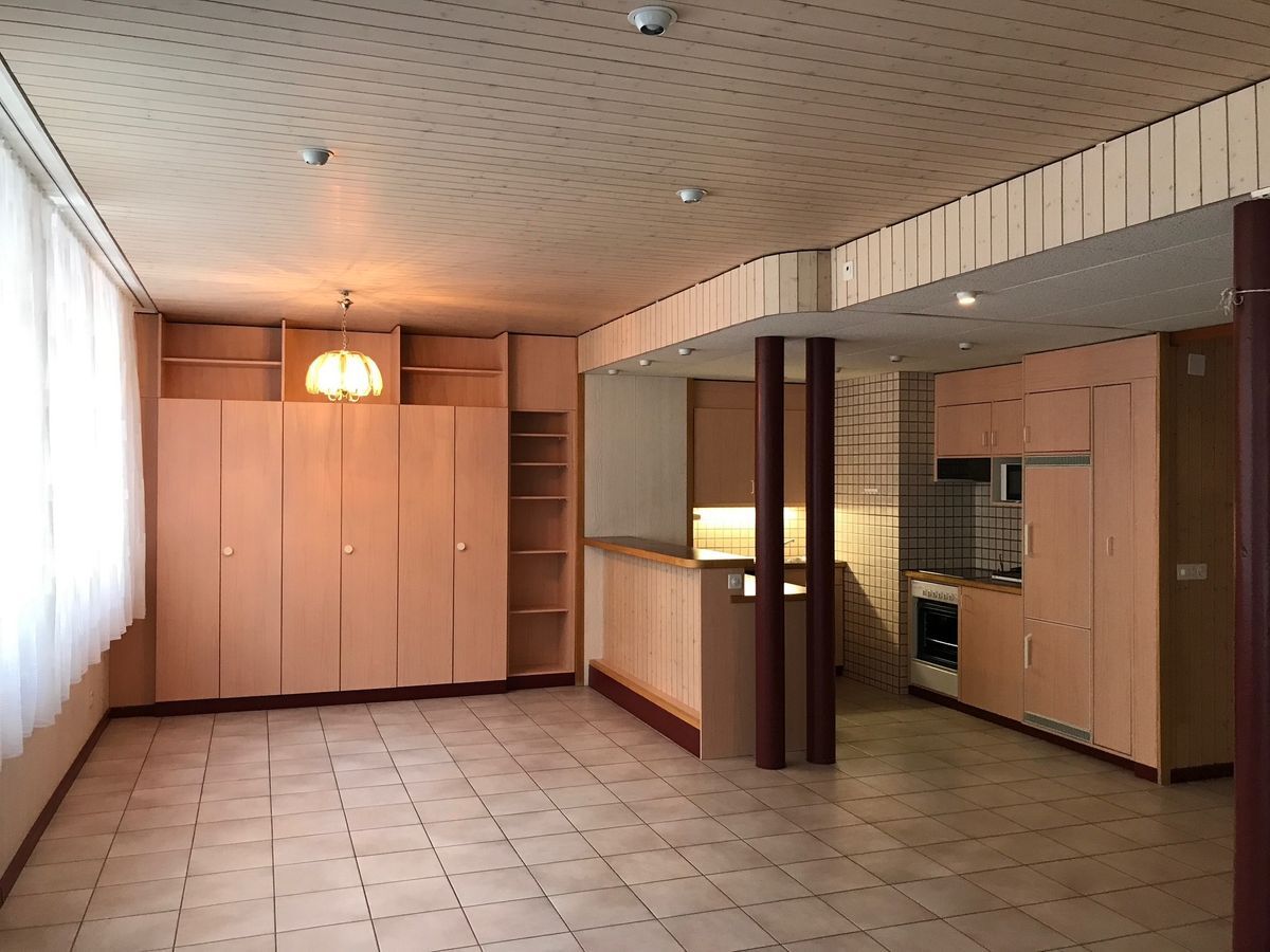 Espace ouvert avec cuisine équipée et rangements intégrés.